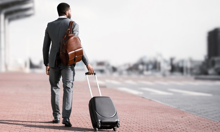 a business man walks outside at an airport